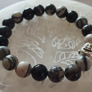 Choisissez le bracelet "Entraide et compassion" en jaspe araignée et tourmaline noire pour favoriser la solidarité et la bienveillance. En effet, ces pierres puissantes vous aident à cultiver des relations harmonieuses et à surmonter les défis ensemble.