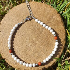Ajoutez une touche d'élégance à votre style avec le bracelet de cheville en Howlite et Jaspe rouge. Ce bijou unique allie la beauté des pierres naturelles à un design raffiné. Profitez de ses bienfaits tout en rehaussant votre look.