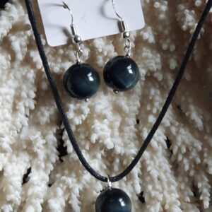 La parure composée de boucles d'oreilles et d'un pendentif en Œil de faucon attire immédiatement l'œil par son élégance et son originalité. En effet, cette combinaison de bijoux met en valeur la beauté unique de la pierre, qui se caractérise par ses nuances de bleu et de gris. De plus, l'Œil de faucon est souvent associé à des propriétés protectrices et apaisantes, ce qui ajoute une dimension spirituelle à cette parure. Ainsi, cet ensemble de bijoux allie esthétique et symbolisme, séduisant ceux qui souhaitent exprimer leur style tout en bénéficiant des vertus de la pierre.