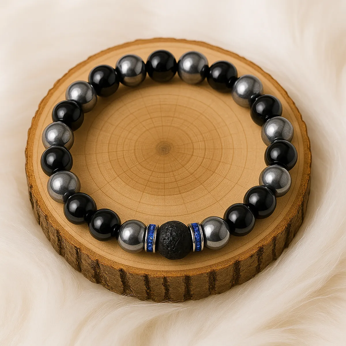 Bracelet de protection en obsidienne argentée, hématite et pierre de lave posé sur un rondin de bois.
