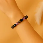 Bracelet anti-addiction féminin en pierres naturelles porté au poignet.
