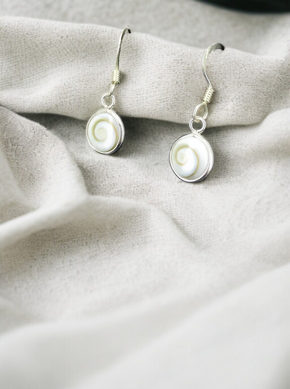 Apportez élégance et protection avec ces boucles d’oreilles Œil de Sainte Lucie. Ce bijou coquillage méditerranéen porte chance, éloigne le mauvais œil et séduit par ses nuances naturelles blanches et orangées. Un accessoire raffiné et chargé d’énergie positive.