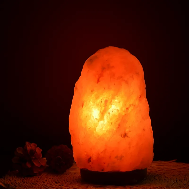 pierres naturelles et minéraux Lampe en Cristal de Sel d’Himalaya allumée diffusant une lumière chaude et apaisante dans une ambiance zen.