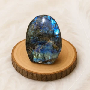 Grand bloc de Labradorite de 1,552 kg présenté sur un rondin de bois