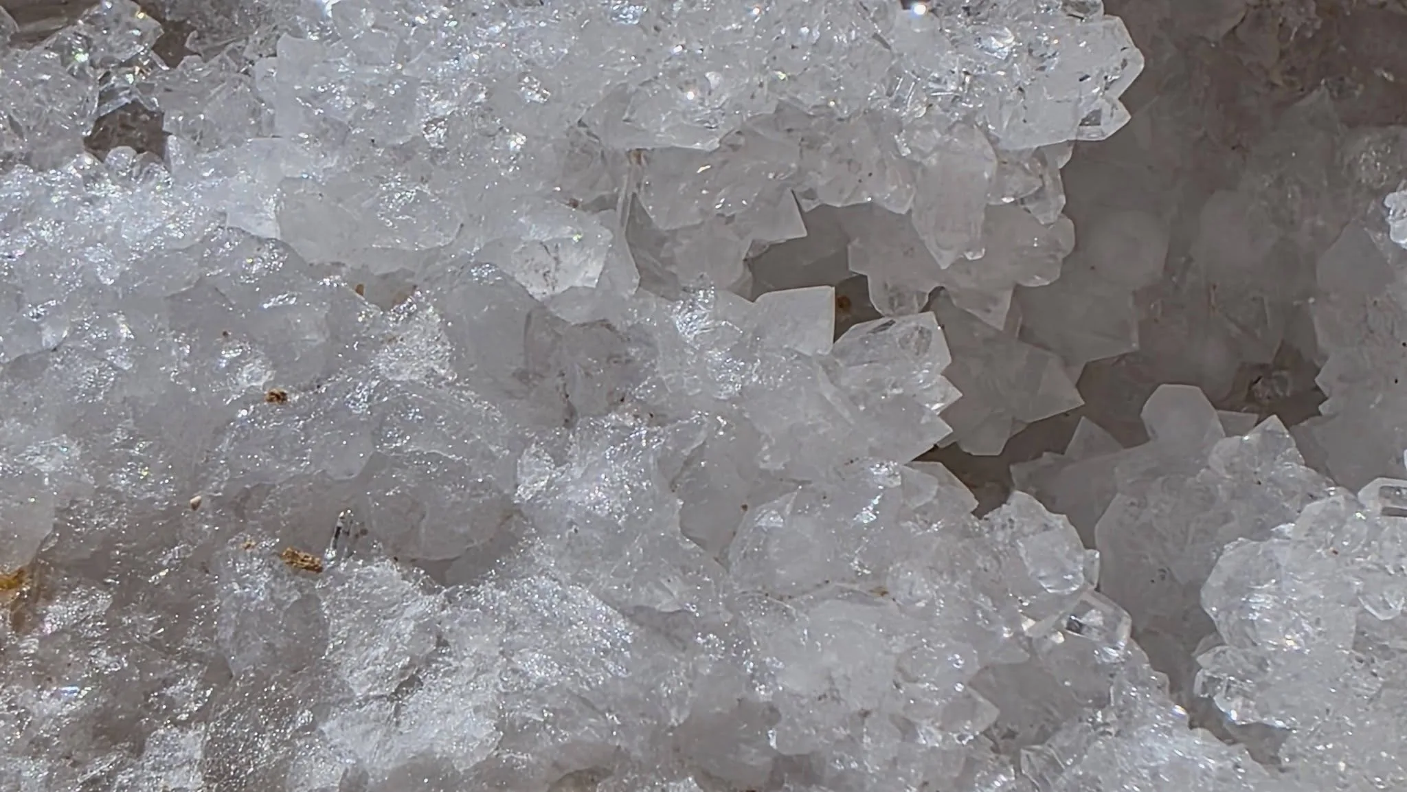 Gros plan sur les cristaux de quartz blanc scintillants à l’intérieur de la géode