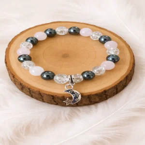 Bracelet bien-être en pierres naturelles cristal de roche, hématite et quartz rose présenté sur rondin en bois