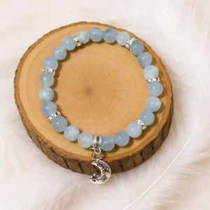Bracelet aigue-marine en pierre naturelle posé sur un rondin de bois