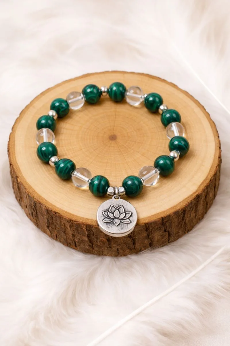 Bracelet énergétique anti douleur en malachite et cristal de roche posé sur rondin de bois