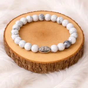Bracelet en pierre howlite naturelle présenté sur rondin en bois