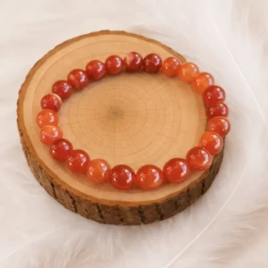 Bracelet cornaline en pierres naturelle posé sur un rondin de bois