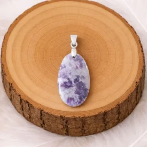 Pendentif lépidolite pierre naturelle violette posé sur rondin en bois