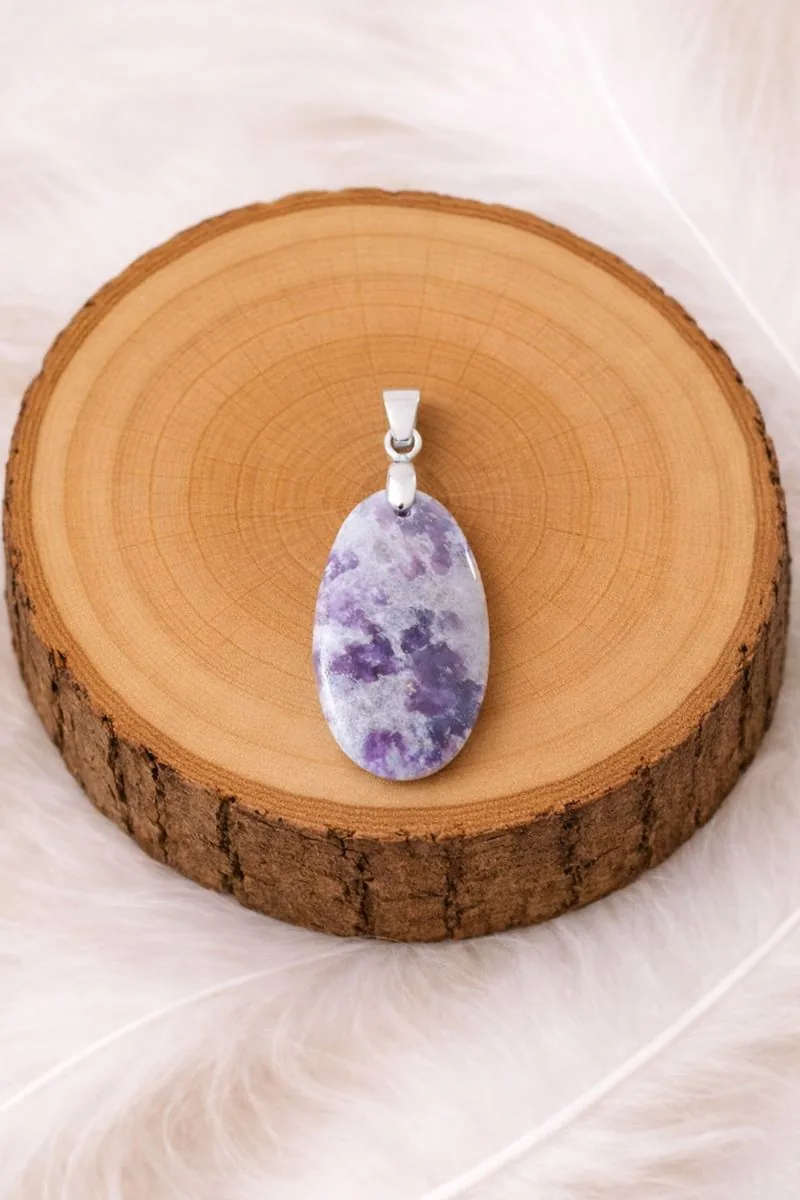 Pendentif lépidolite pierre naturelle violette posé sur rondin en bois