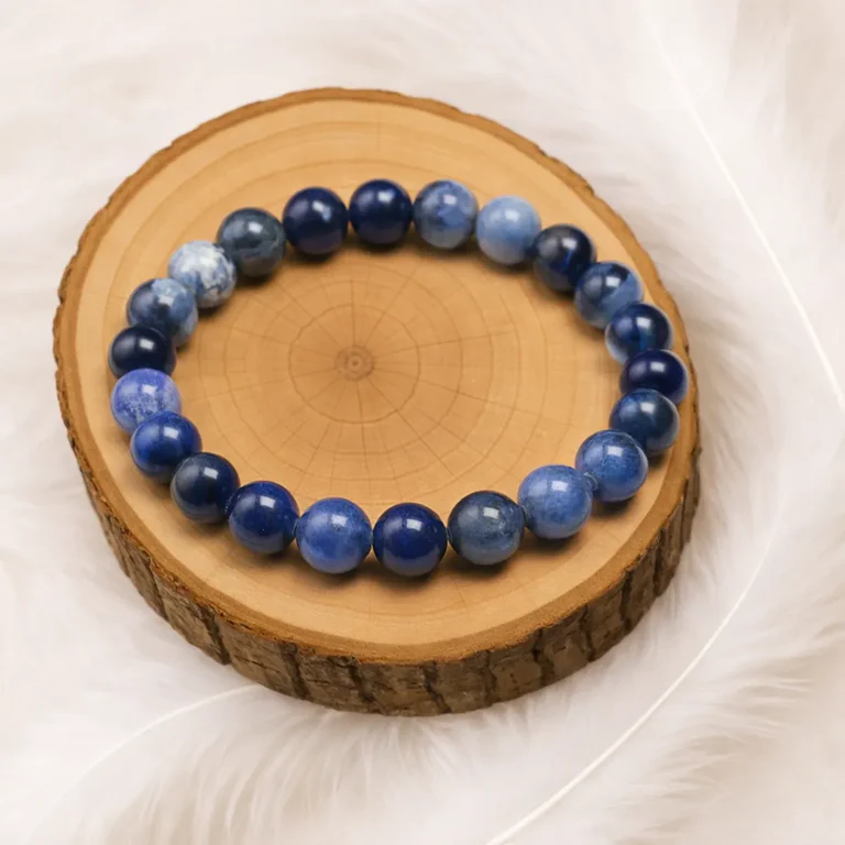 Bracelet sodalite en pierre naturelle posé sur un rondin de bois
