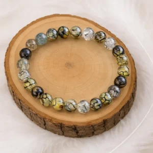 Bracelet en agate veine de dragon aux perles vertes et jaunes posé sur une pierre naturelle