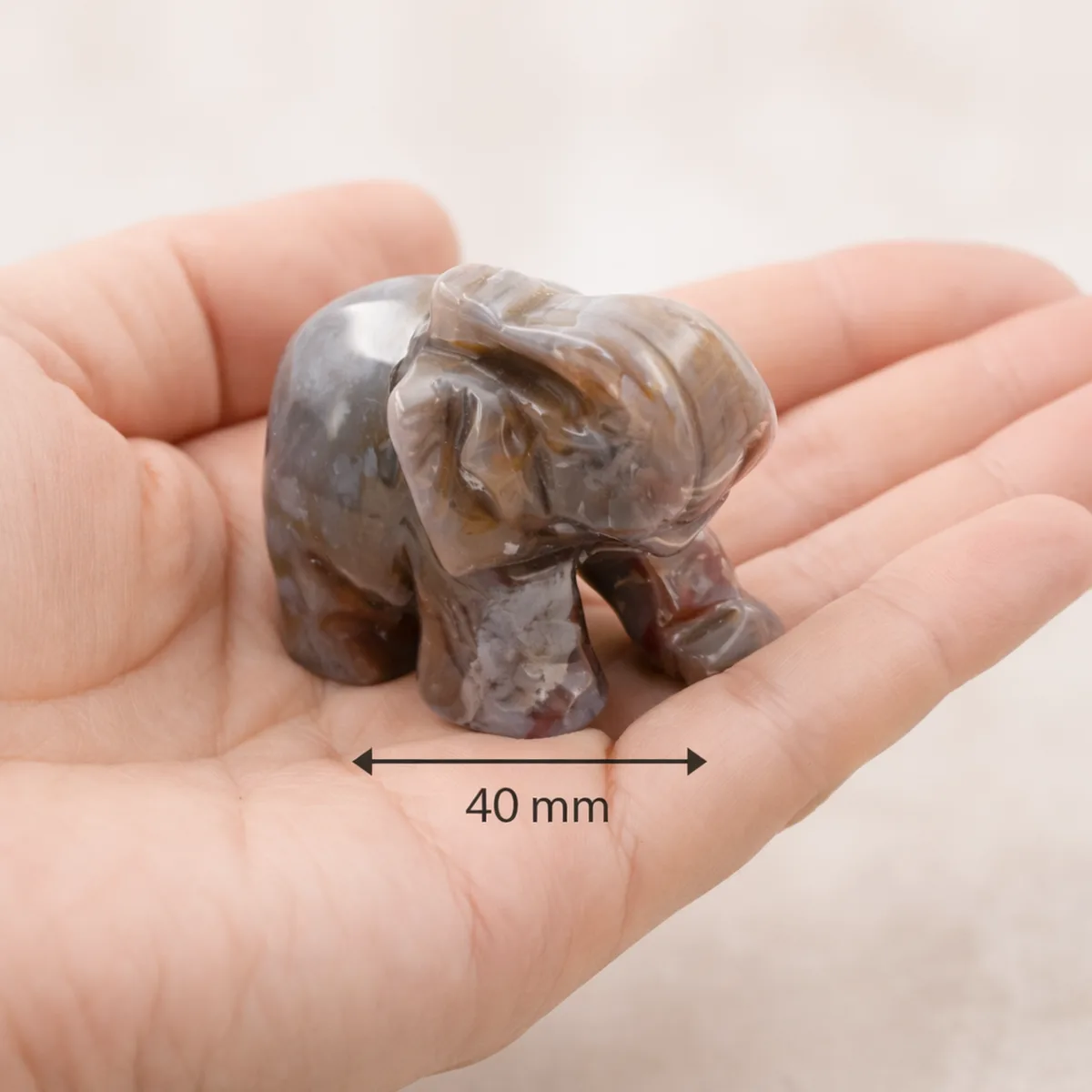 Éléphant en agate indienne naturelle de 40 mm tenu dans une main pour montrer sa taille réelle
