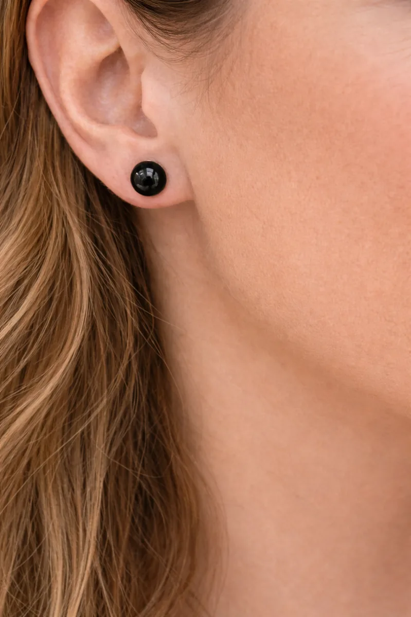 Puce d’oreille onyx noir en argent 925 portée sur lobe, cheveux visibles