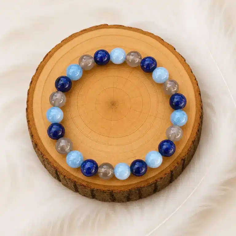 Bracelet allergie en pierres naturelles bleues et grises présenté sur un rondin en bois
