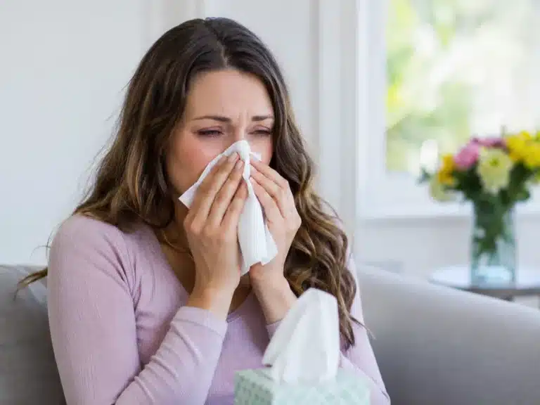 Femme souffrant d’une allergie au pollen et utilisant un mouchoir