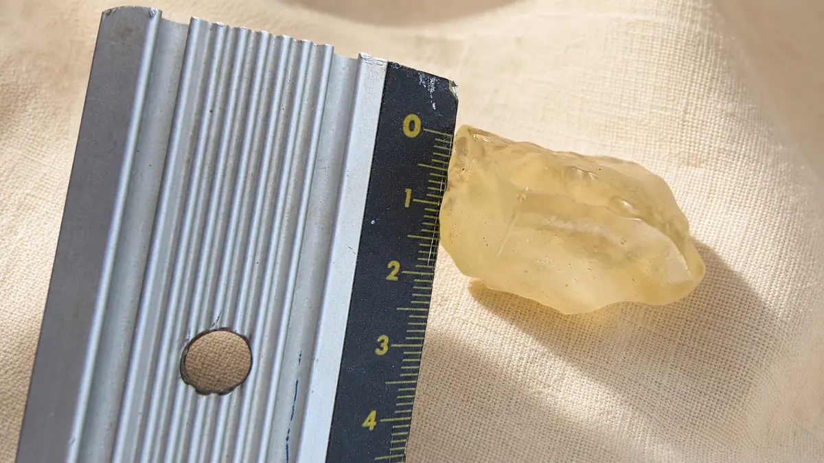 Vue latérale d’une tectite dorée en verre du désert de Libye