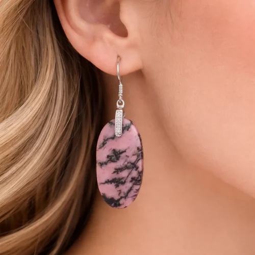 Boucles d’oreilles en rhodonite naturelle portées à l’oreille avec bélière en argent 925